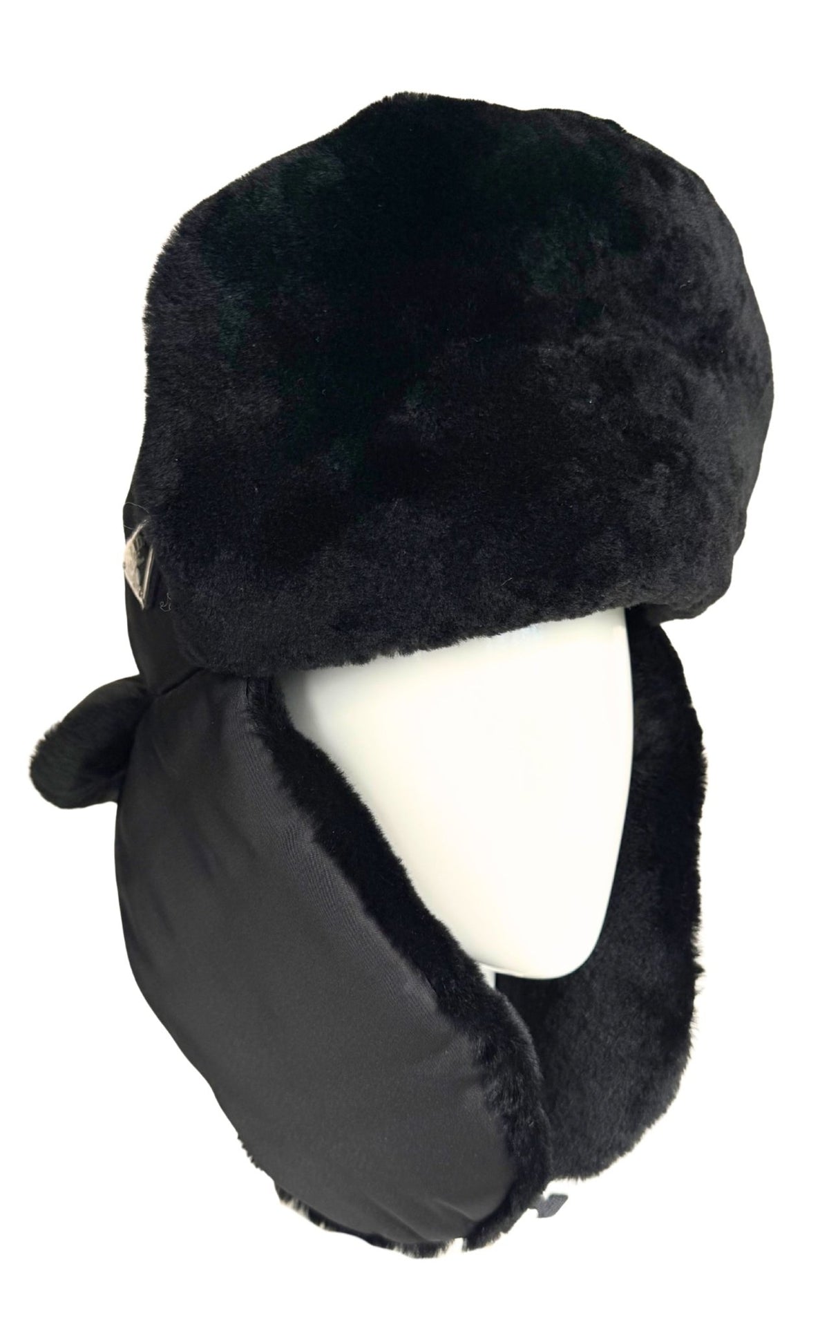 A black faux fur and nylon winter trapper hat with ear flaps, displayed on a white mannequin head against a white background.