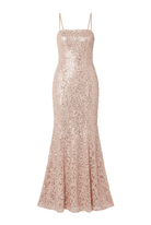 A floor-length, spaghetti-strap gown covered in shimmering blush pink sequins, shown against a plain light background.