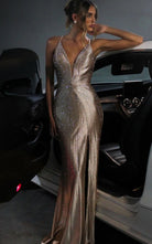 Gold rhinestone mermaid formal dress v plunge front view on a model posing in front of a car