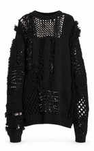 A black distressed open-knit sweater with frayed details and patchwork crochet panels, shown against a plain white background.
