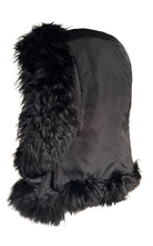 A black Prada winter trapper hat featuring a textured fabric body and fluffy black faux fur trim on the ear flaps and brim, shown against a plain white background.