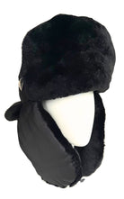 A black faux fur and nylon winter trapper hat with ear flaps, displayed on a white mannequin head against a white background.