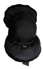 A black winter trapper hat with faux fur trim, featuring a padded crown, ear flaps, and chin strap with a silver metal snap closure, shown against a plain white background.